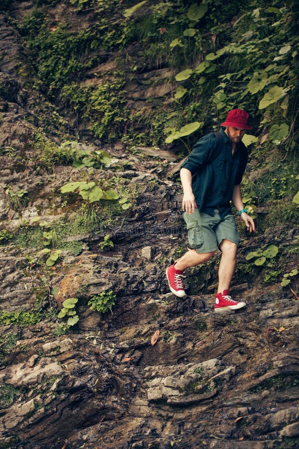 Turista s batohem procházky v horském lese, lezení na útes