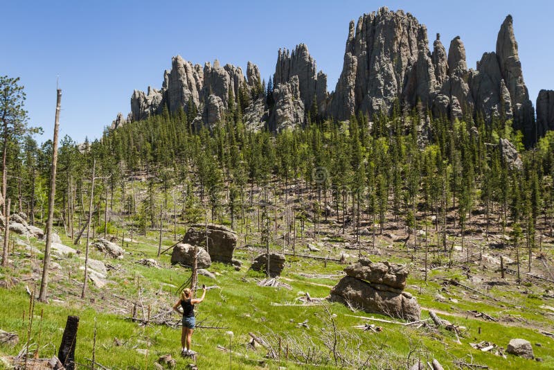 Female hiker taking a picture with her phone of the large granite formations. Female hiker taking a picture with her phone of the large granite formations