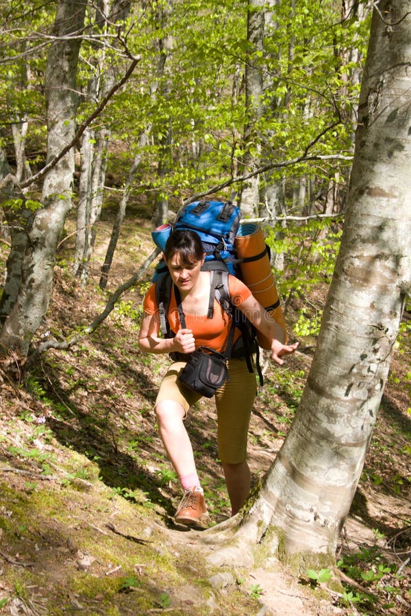 Hiker girl with backpack in spring forest