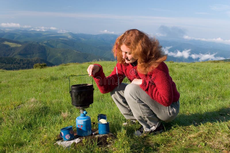 Hiker girl making a coffee royalty free stock photo