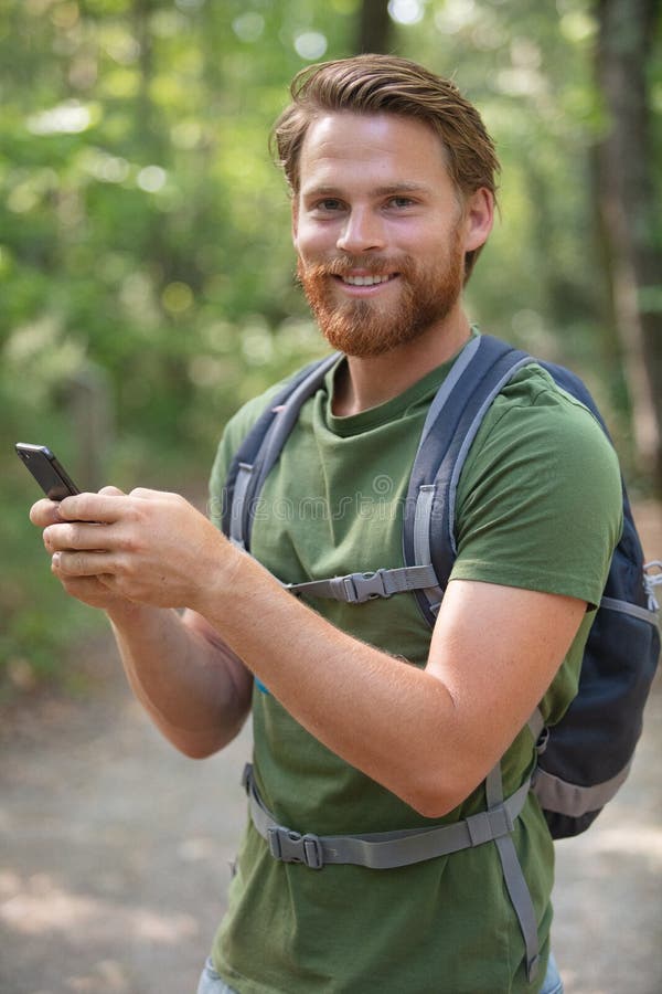 Hiker Man with Mountain Backpacker Making Phone Call Stock Photo
