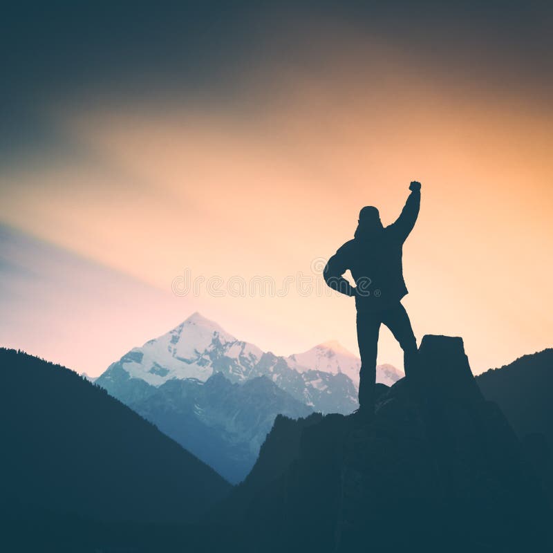 Hiker who conquered the top of mountain standing on a cliffs edge with raised hand and enjoying sunrise above great caucasian mountain Titnuldi. Georgia, Swanetia. Instagram stylisation. Hiker who conquered the top of mountain standing on a cliffs edge with raised hand and enjoying sunrise above great caucasian mountain Titnuldi. Georgia, Swanetia. Instagram stylisation.
