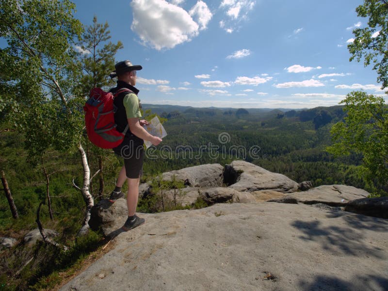 Hiker in shorts wear cowboy hat and red back pack, stay on rock royalty free stock images Hiker in shorts wear cowboy hat and red back pack, stay on rock royalty free stock images