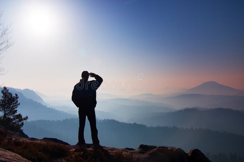 Hiker is standing on the peak of rock in rock empires park and watching over the misty and foggy morning valley to Sun royalty free stock photography Hiker is standing on the peak of rock in rock empires park and watching over the misty and foggy morning valley to Sun royalty free stock photography