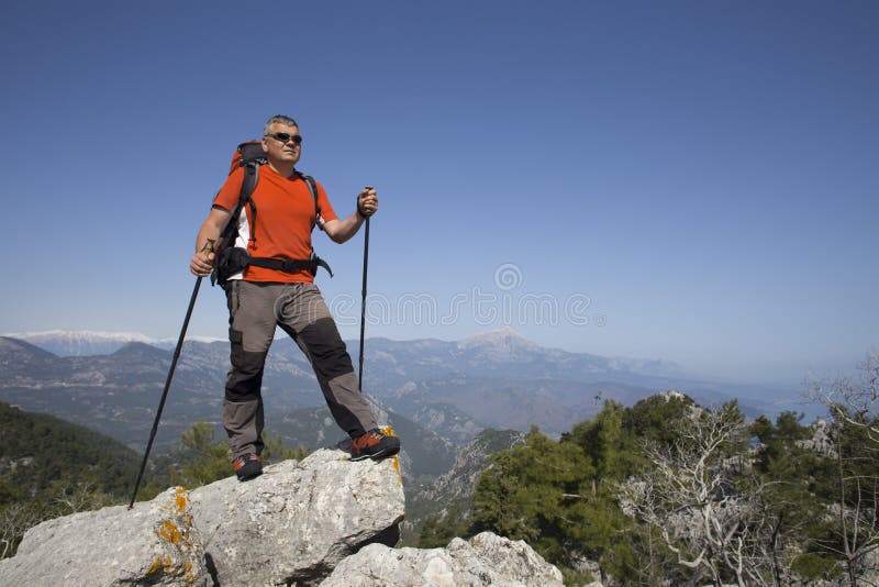 Hiker Standing On Top Of The Mountain With Valley On The Background