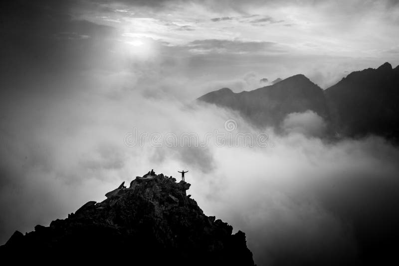 Turista na vrcholu kopce otevřenou náruč. Černobílá fotografie