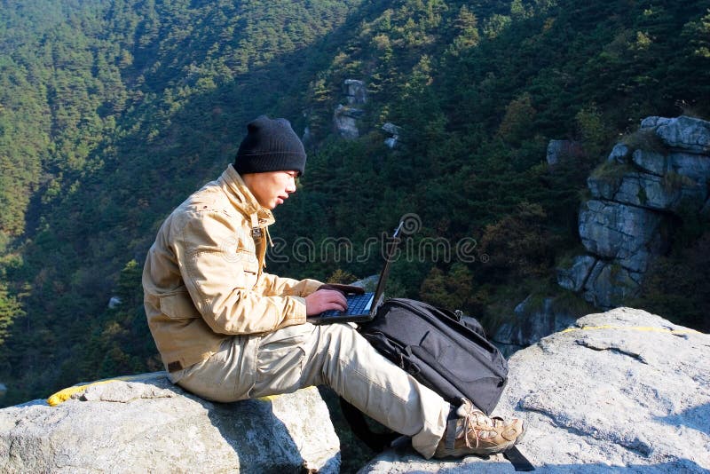 Hiker using a laptop outdoors