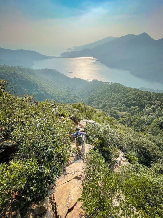 Hiker walking downhill from peak, Lantau Island, Hong Kong