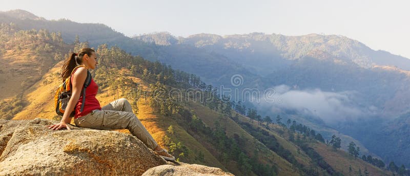 Hiker при рюкзак ослабляя на утесе и наслаждаясь красивым mou стоковые фото Hiker при рюкзак ослабляя на утесе и наслаждаясь красивым mou стоковые фото