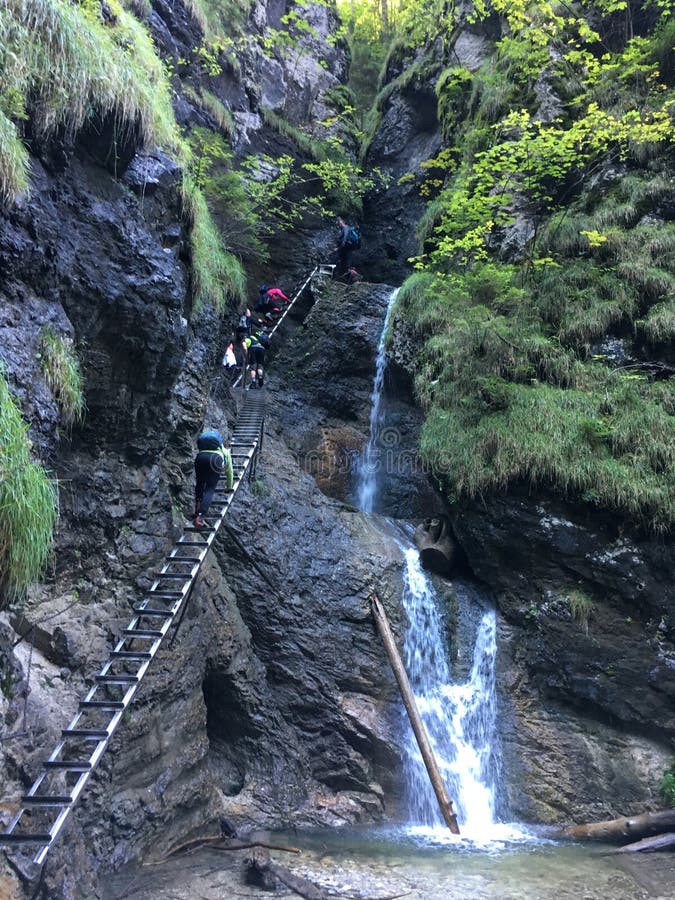 Hikers climb stairs up to gorge near waterfall