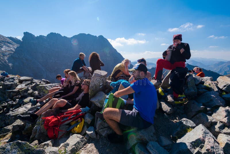 Hikers on the mountain summit. Zakopane, Poland - Sept 19, 2018: Hikers resting on the Koscielec peak in the High Tatras, Poland royalty free stock photography Hikers on the mountain summit. Zakopane, Poland - Sept 19, 2018: Hikers resting on the Koscielec peak in the High Tatras, Poland royalty free stock photography