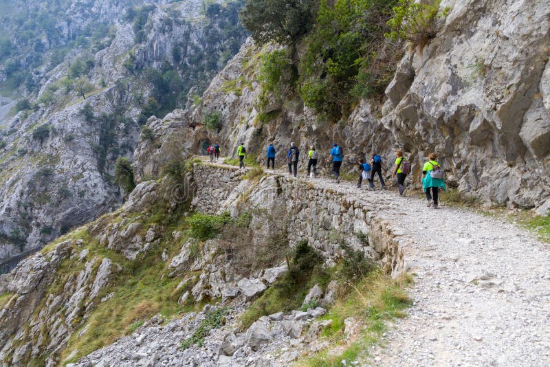 Hikers by amazing Cares river canyon pathway in Asturias, north Spain. Hikers by amazing Cares river canyon pathway in Asturias, north Spain