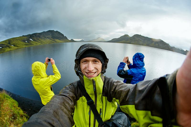 Hikers на озере плавают вдоль побережья с отражением горы, Исландией стоковое изображение rf Hikers на озере плавают вдоль побережья с отражением горы, Исландией стоковое изображение rf