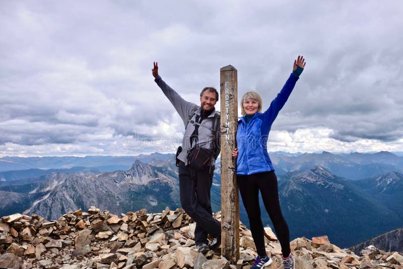 Middle age people on mountain top looking happy and successful. royalty free stock photos