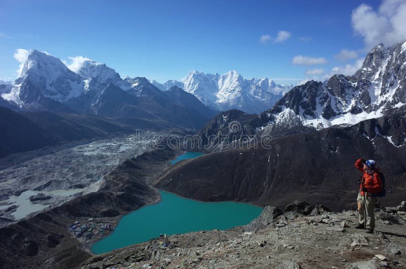 Hiking in Nepal Himalayas, Male tourist on Gokyo Ri with view of Gokyo lake, Gokyo village, Ngozumba glacier and mountain