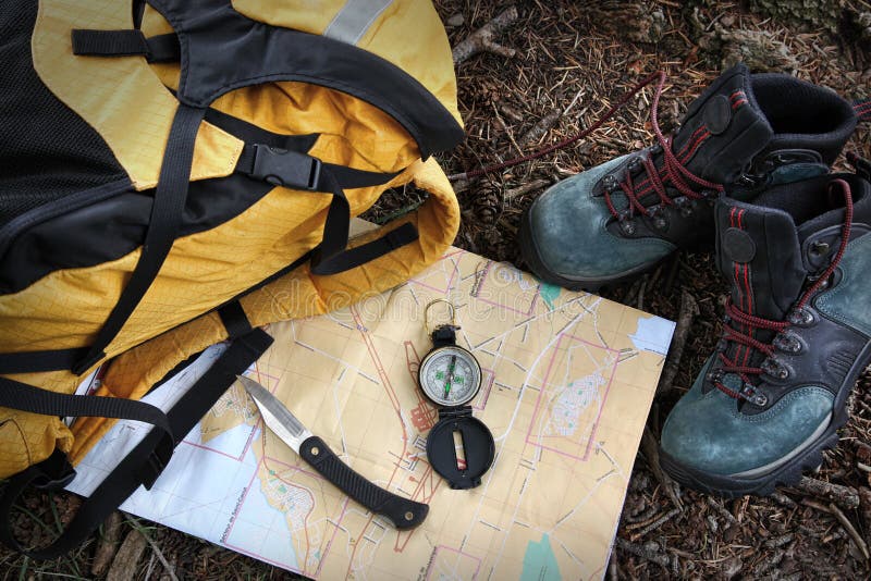 Turistická obuv na mape pomocou kompasu a batoh.