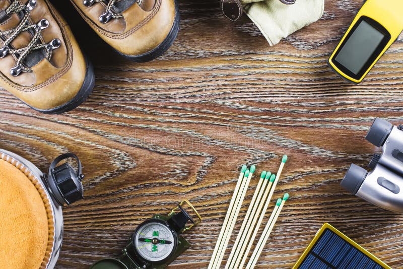 Hiking or travel equipment with boots, compass, binoculars, matches on wooden background. Active lifestyle concept stock image Hiking or travel equipment with boots, compass, binoculars, matches on wooden background. Active lifestyle concept stock image