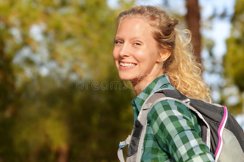 Hiking woman portrait smiling happy in forest. Female hiker girl