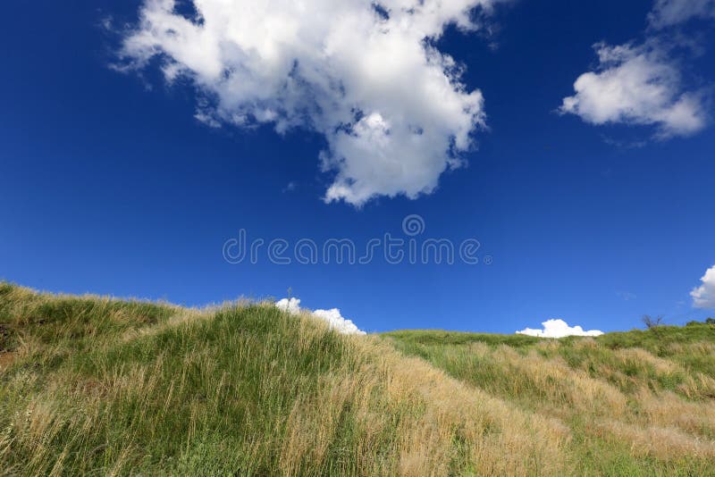 Hill under blue sky with clouds royalty free stock photo