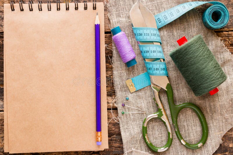 Hilo, tijeras, cinta métrica y un cuaderno para las notas imagen de archivo libre de regalías Hilo, tijeras, cinta métrica y un cuaderno para las notas imagen de archivo libre de regalías