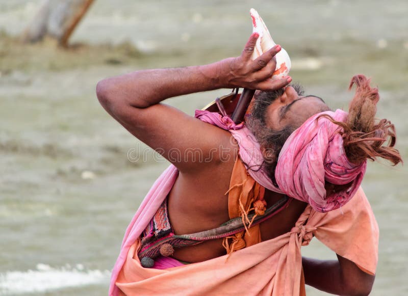 Hindu sadhu (saint) is blowing shell trumpet at Kumbh Mela, Prayag. Hindu sadhu (saint) is blowing shell trumpet at Kumbh Mela, Prayag.