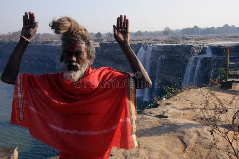 A Hindu monk is busy in his daily ritual in the morning in front of Chitrakote waterfall..