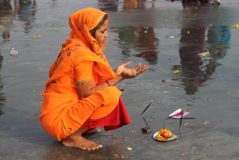 A Hindu woman praying at the Ganges .