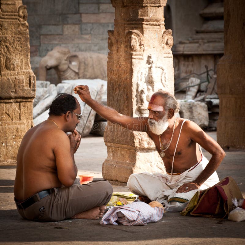 Hinduski bramin błogosławi ludzi przy Meenakshi świątynią z religijnymi atrybutami India, Madurai, tamil nadu zdjęcie stock Hinduski bramin błogosławi ludzi przy Meenakshi świątynią z religijnymi atrybutami India, Madurai, tamil nadu zdjęcie stock