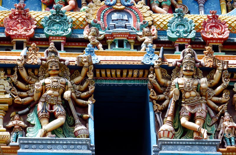 Colored statue on the wall in front of the entrance to the hindu temple with ornament and decorations. Man and woman figure, statues of hindu gods such as Ganesh, Vishnu, Shiva and Krishna, Minakshi godess and mytholigical creatures with many hands or eyes. Colored statue on the wall in front of the entrance to the hindu temple with ornament and decorations. Man and woman figure, statues of hindu gods such as Ganesh, Vishnu, Shiva and Krishna, Minakshi godess and mytholigical creatures with many hands or eyes.