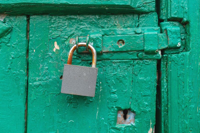 Hinged metal lock on old green wooden door stock image Hinged metal lock on old green wooden door stock image