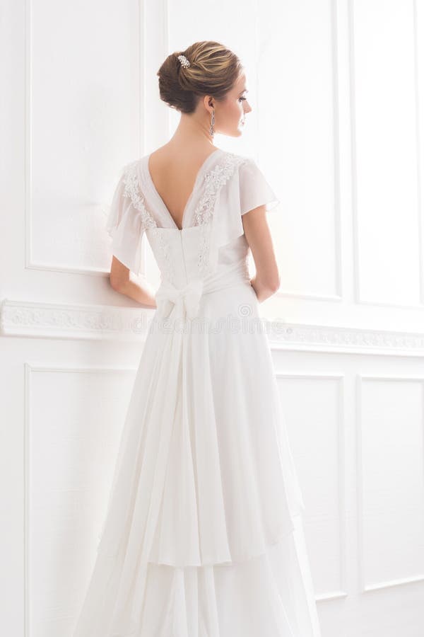 Hintere Ansicht der jungen und schönen Braut im weißen Kleid lizenzfreie stockfotos Hintere Ansicht der jungen und schönen Braut im weißen Kleid lizenzfreie stockfotos