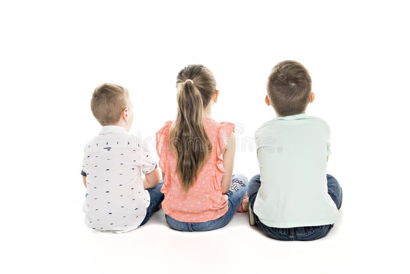 Hintere Ansicht der Kindergruppe sitzend auf dem Boden, der Wand betrachtet stockfoto