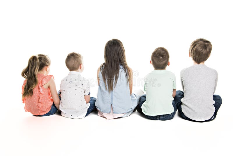 Hintere Ansicht der Kindergruppe sitzend auf dem Boden, der Wand betrachtet stockfotografie