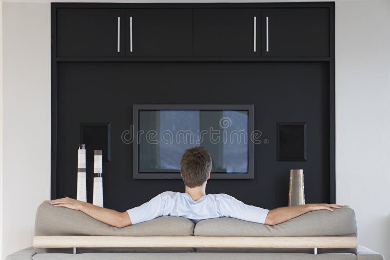 Hintere Ansicht des Mann-aufpassenden Fernsehens lizenzfreies stockbild