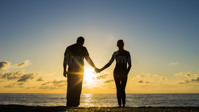 Hintere Ansicht eines Paares silhouettieren umarmende und aufpassende Sonne auf dem Strand lizenzfreie stockfotografie Hintere Ansicht eines Paares silhouettieren umarmende und aufpassende Sonne auf dem Strand lizenzfreie stockfotografie