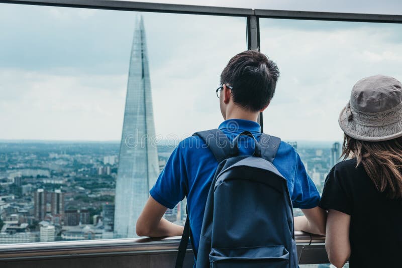Hintere Ansicht von den Leuten, die auf einem Freilichtbalkon im Himmel-Garten, London, Großbritannien stehen lizenzfreies stockbild Hintere Ansicht von den Leuten, die auf einem Freilichtbalkon im Himmel-Garten, London, Großbritannien stehen lizenzfreies stockbild