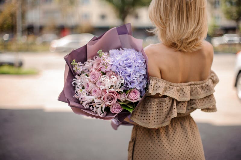 Hintere Ansicht von schönen Blondinen im beige Kleid, das ein ROM hält lizenzfreie stockfotografie Hintere Ansicht von schönen Blondinen im beige Kleid, das ein ROM hält lizenzfreie stockfotografie