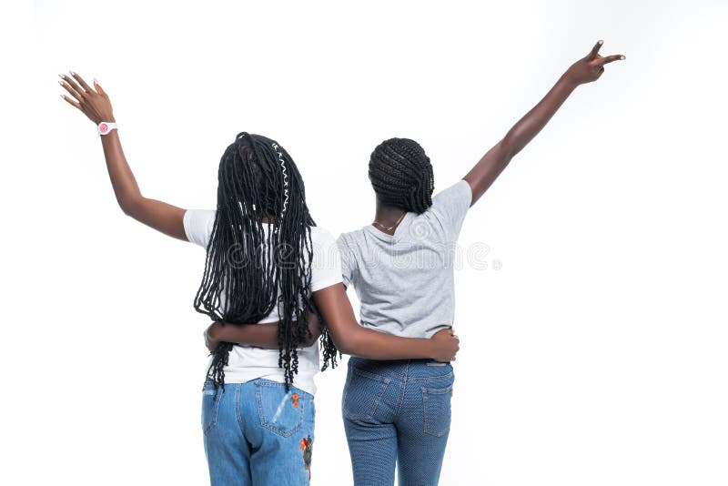 Hintere Ansicht von zwei afrikanischen Frauen mit den angehobenen Händen lokalisiert über weißem Hintergrund lizenzfreies stockbild Hintere Ansicht von zwei afrikanischen Frauen mit den angehobenen Händen lokalisiert über weißem Hintergrund lizenzfreies stockbild