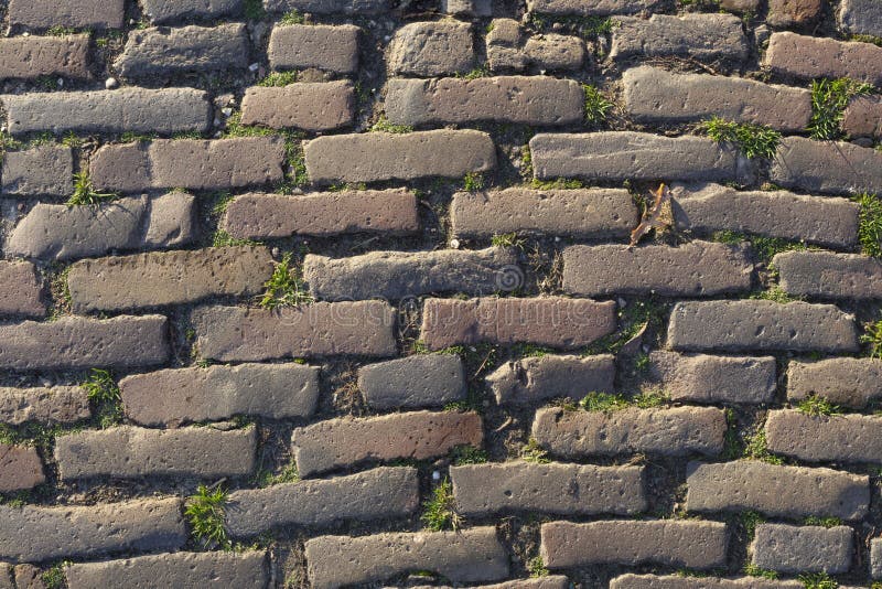 Background image of old brickstone road backlit with low sunlight - Image. Background image of old brickstone road backlit with low sunlight - Image