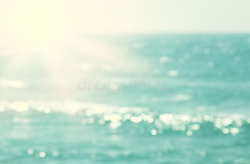 Hintergrund des unscharfen Strandes und Meereswellen mit bokeh Sonnenuntergang beleuchten lizenzfreies stockbild Hintergrund des unscharfen Strandes und Meereswellen mit bokeh Sonnenuntergang beleuchten lizenzfreies stockbild