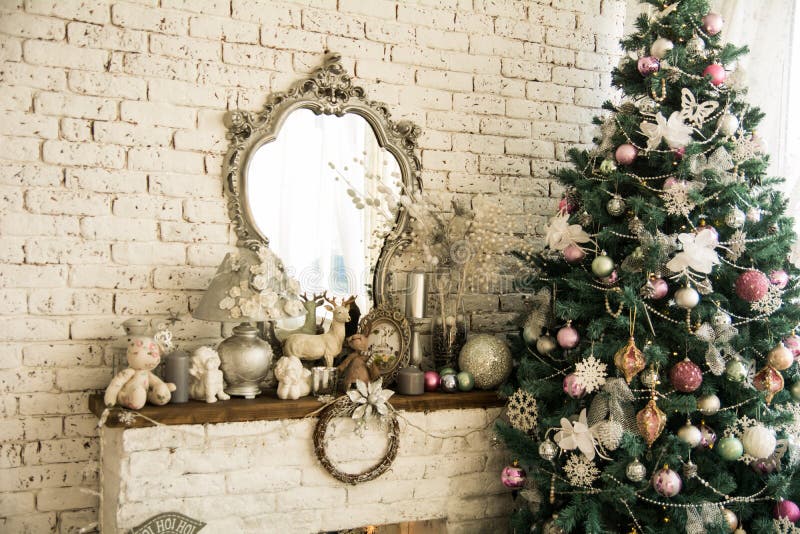 Background brick wall with a mirror Christmas spruce. Toys and figurines on mantel. Background brick wall with a mirror Christmas spruce. Toys and figurines on mantel.