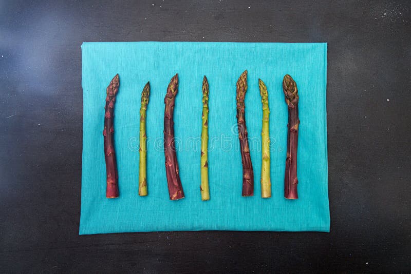 Hintergrundebene legen grünen purpurroten Spargel auf Blau Feldschwarzes stockfoto Hintergrundebene legen grünen purpurroten Spargel auf Blau Feldschwarzes stockfoto