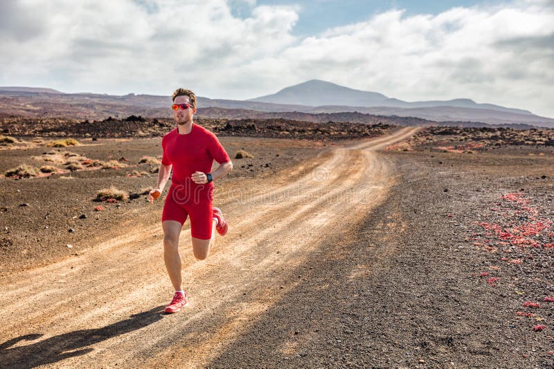 Hinterlaufender Athleteneignungs-Mannläufer, der auf tragender Kompressionskleidung des Wüstenschotterwegs und tragbarem Technolo lizenzfreie stockbilder Hinterlaufender Athleteneignungs-Mannläufer, der auf tragender Kompressionskleidung des Wüstenschotterwegs und tragbarem Technolo lizenzfreie stockbilder