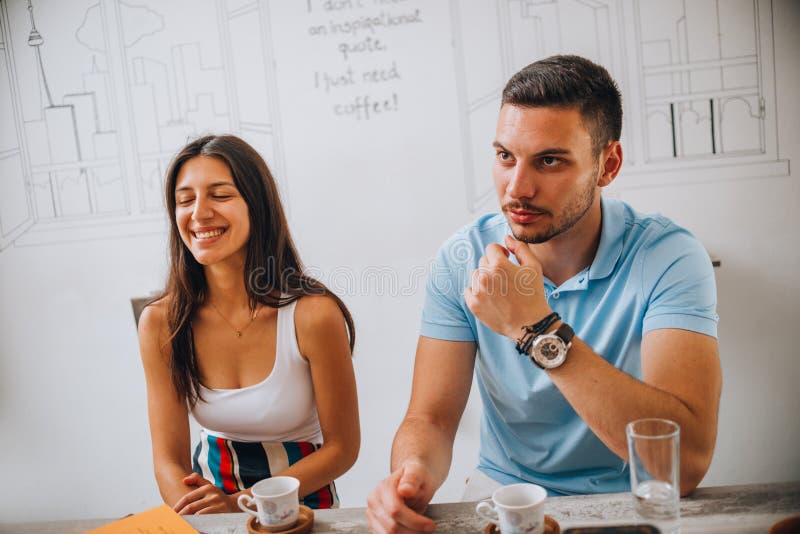 Hip jeune couple prenant un café ensemble au café le jour du soleil photographie stock Hip jeune couple prenant un café ensemble au café le jour du soleil photographie stock