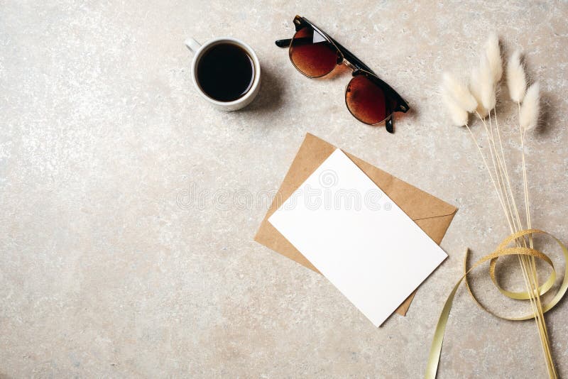 Hippie-Ausgangsschreibtischarbeitsplatz mit Sonnenbrille, Karte des leeren Papiers und Kraftpapier-Umschlag, trockene Blume mit B stockfotografie Hippie-Ausgangsschreibtischarbeitsplatz mit Sonnenbrille, Karte des leeren Papiers und Kraftpapier-Umschlag, trockene Blume mit B stockfotografie