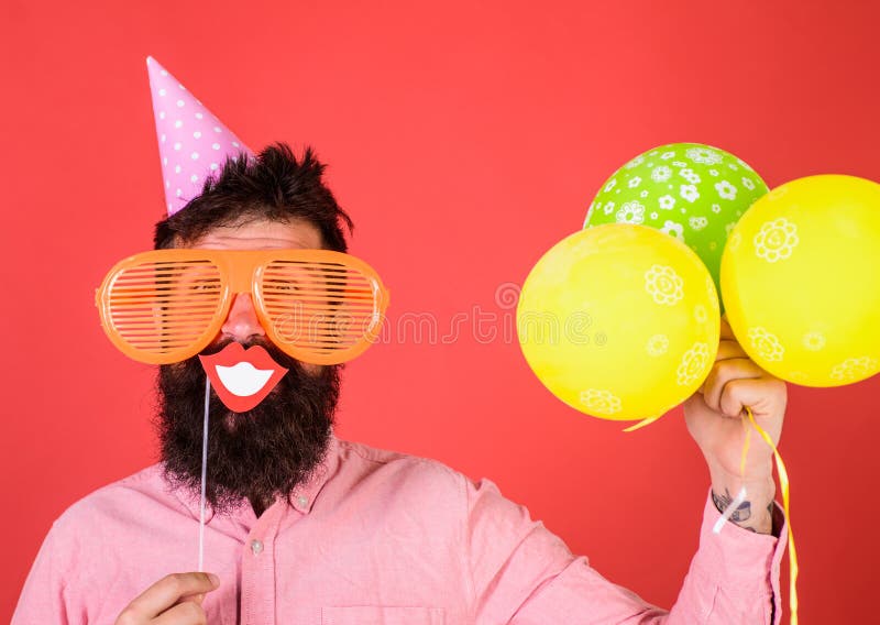 Hippie in der riesigen Sonnenbrille feiernd Kerl im Parteihut mit Luftballonen feiert Passfotoautomatspaßkonzept Mann