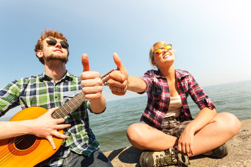 Hippie des jungen Mannes mit Gitarre und Frau stockfotografie Hippie des jungen Mannes mit Gitarre und Frau stockfotografie