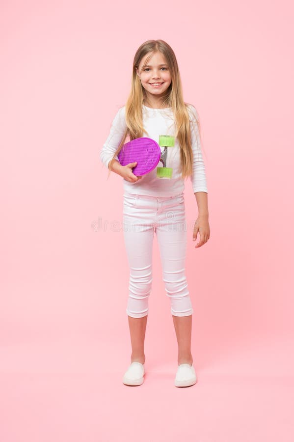 Hippie frais Petite planche à roulettes mignonne de participation de hippie sur le fond rose Petit patineur adorable souriant ave photo stock Hippie frais Petite planche à roulettes mignonne de participation de hippie sur le fond rose Petit patineur adorable souriant ave photo stock