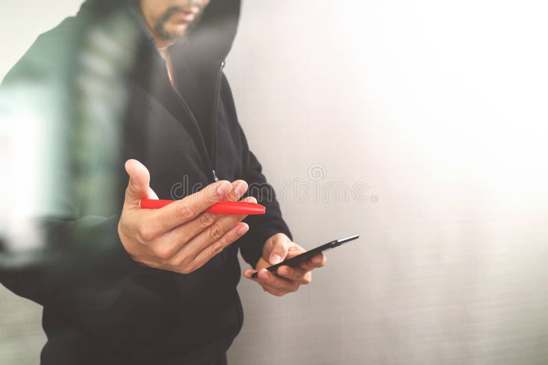 Hippie-Mann in einer Haubenhand unter Verwendung Handyzahlungen on-line-s stockbilder Hippie-Mann in einer Haubenhand unter Verwendung Handyzahlungen on-line-s stockbilder