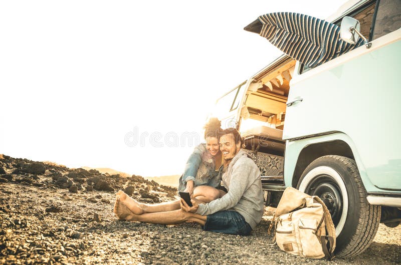 Hippie-Paare, die zusammen auf Oldtimerminipackwagentransport reisen lizenzfreie stockfotografie Hippie-Paare, die zusammen auf Oldtimerminipackwagentransport reisen lizenzfreie stockfotografie